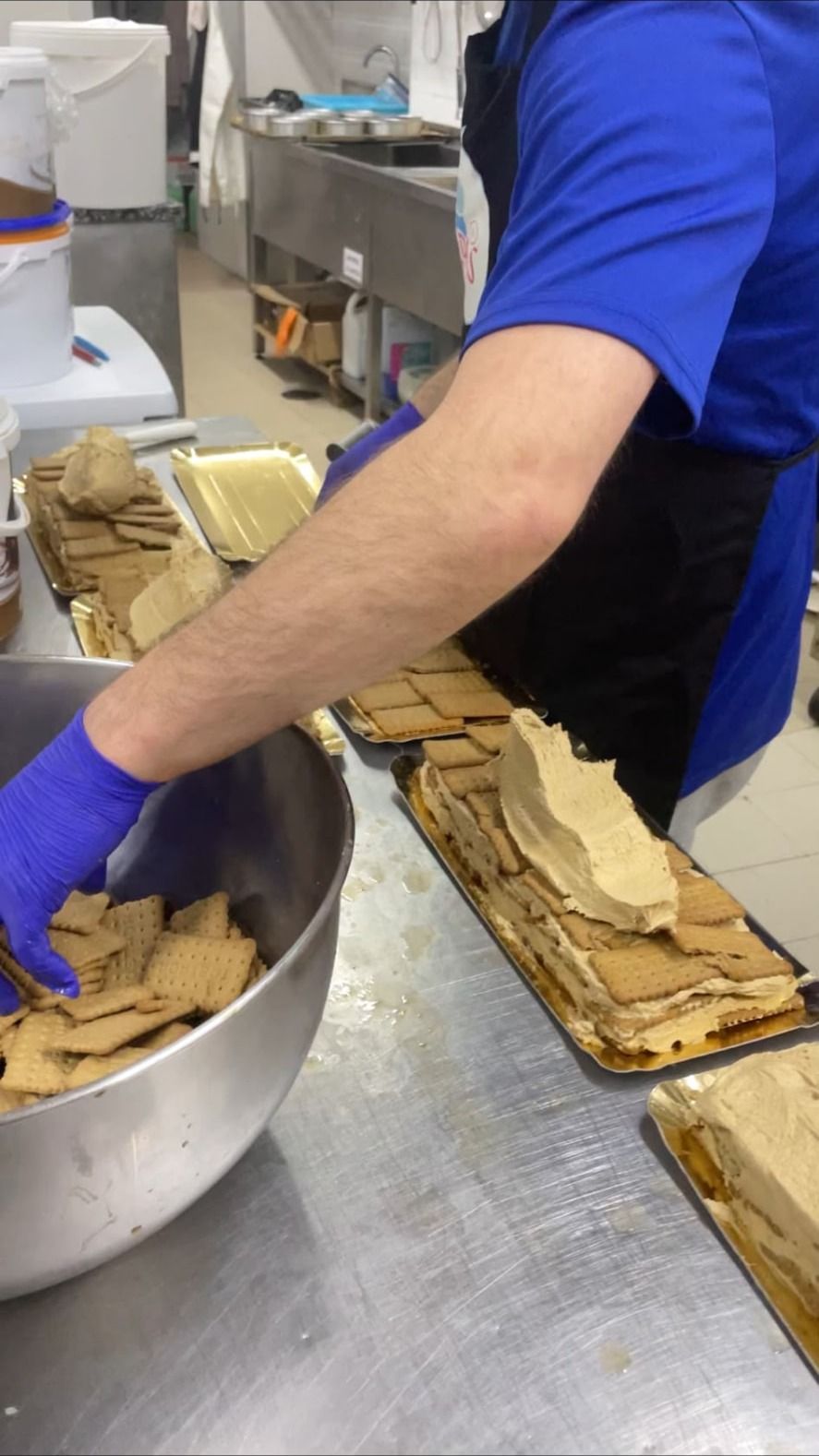 Preparação artesanal de bolo de bolacha tradicional, com bolacha e creme dispostos à mão